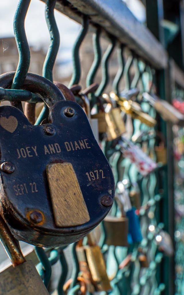 Ein Vorhängeschloss, graviert mit 'Joey and Diane Sep 22 1972', angebracht an einem Geländer voller Liebesschlösser.